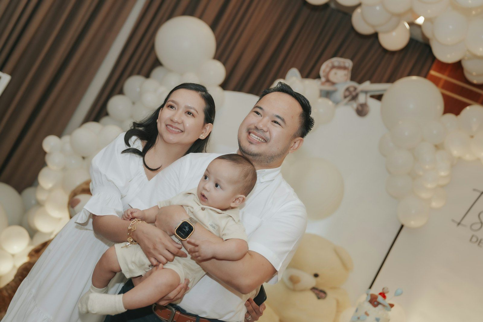A family holding their baby at a christening party
