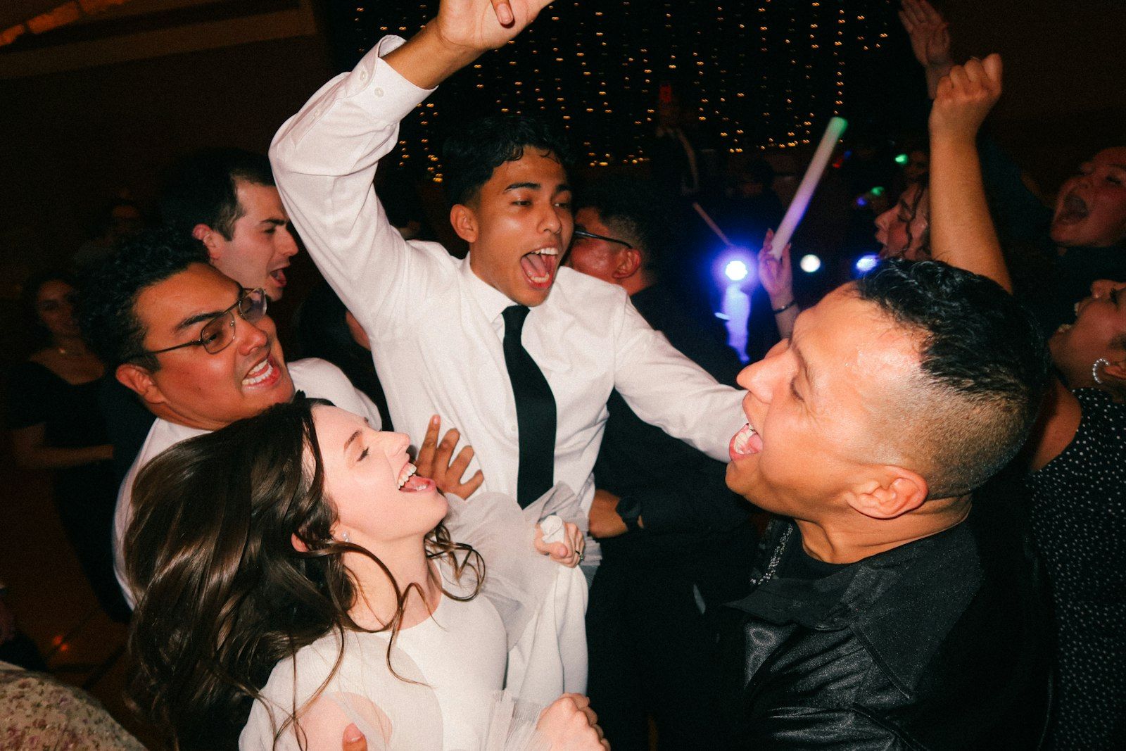 Guests cheering and dancing at a reception